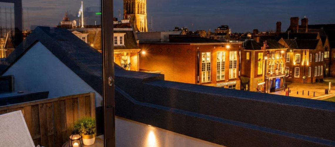 Leicester city rooftops and church spire at dusk